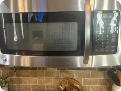 Front view of a stainless steel GE over-the-range microwave and keypad.