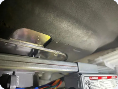 Close-up from the work gallery showing an internal metal housing, bracket and adjoining plastic components.