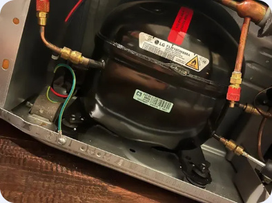 LG linear compressor with connected copper tubing and service fittings visible.