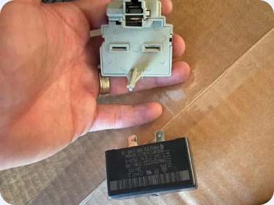 Hand-held compressor start-device housing with a separate capacitor visible below.