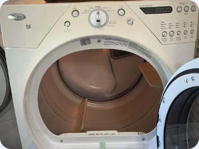 White Whirlpool dryer with its door open, showing the drum, lint-screen area and front controls.