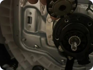 Exposed threaded drive shaft and surrounding circular mounting components inside an appliance cabinet.