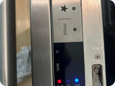 Dishwasher upper-door control strip showing illuminated indicators and a rinse marking.
