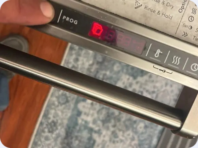 Close view of a dishwasher upper-door control panel with an illuminated red digital display.