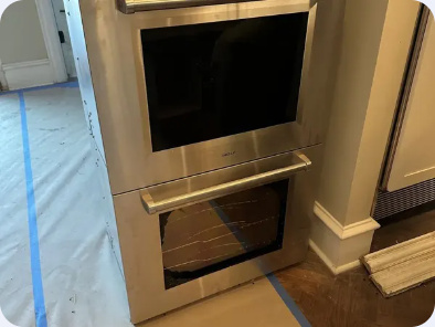 Stainless steel built-in cooking appliance set into a tall kitchen cabinet.
