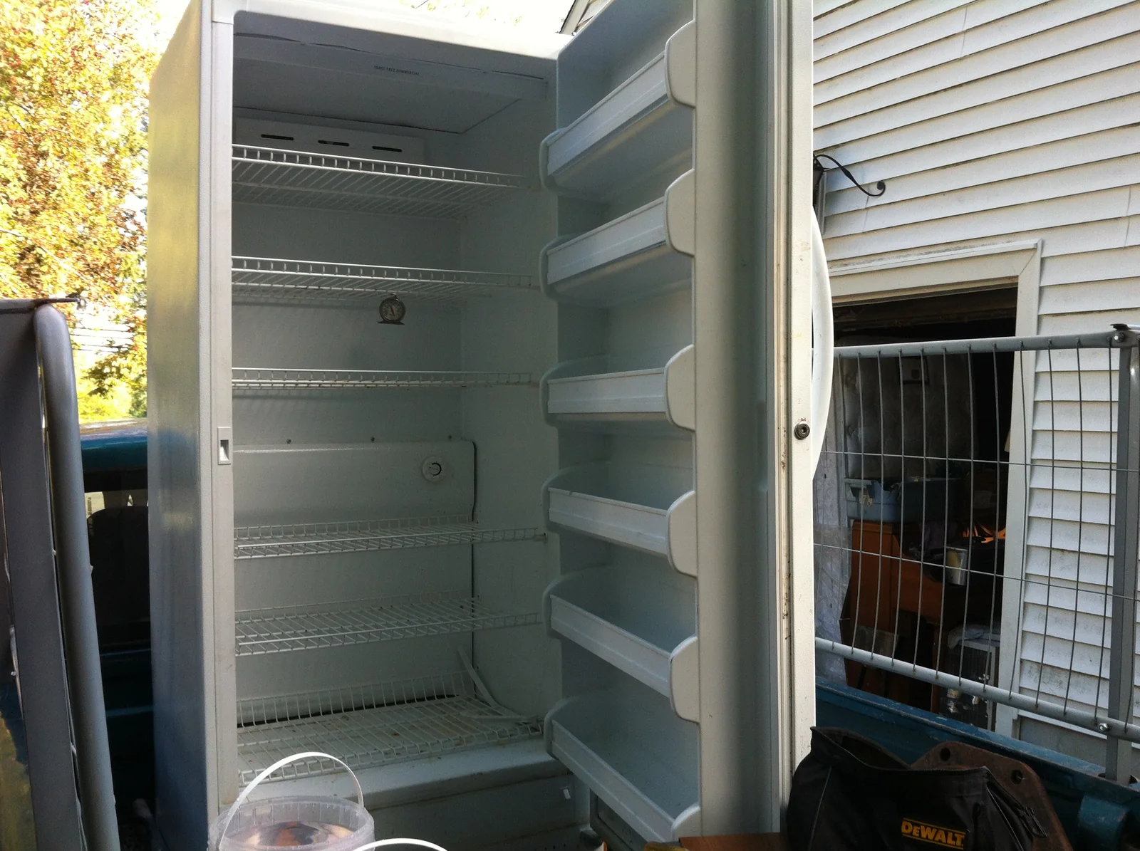 Open Frigidaire upright freezer showing its shelves and door liner