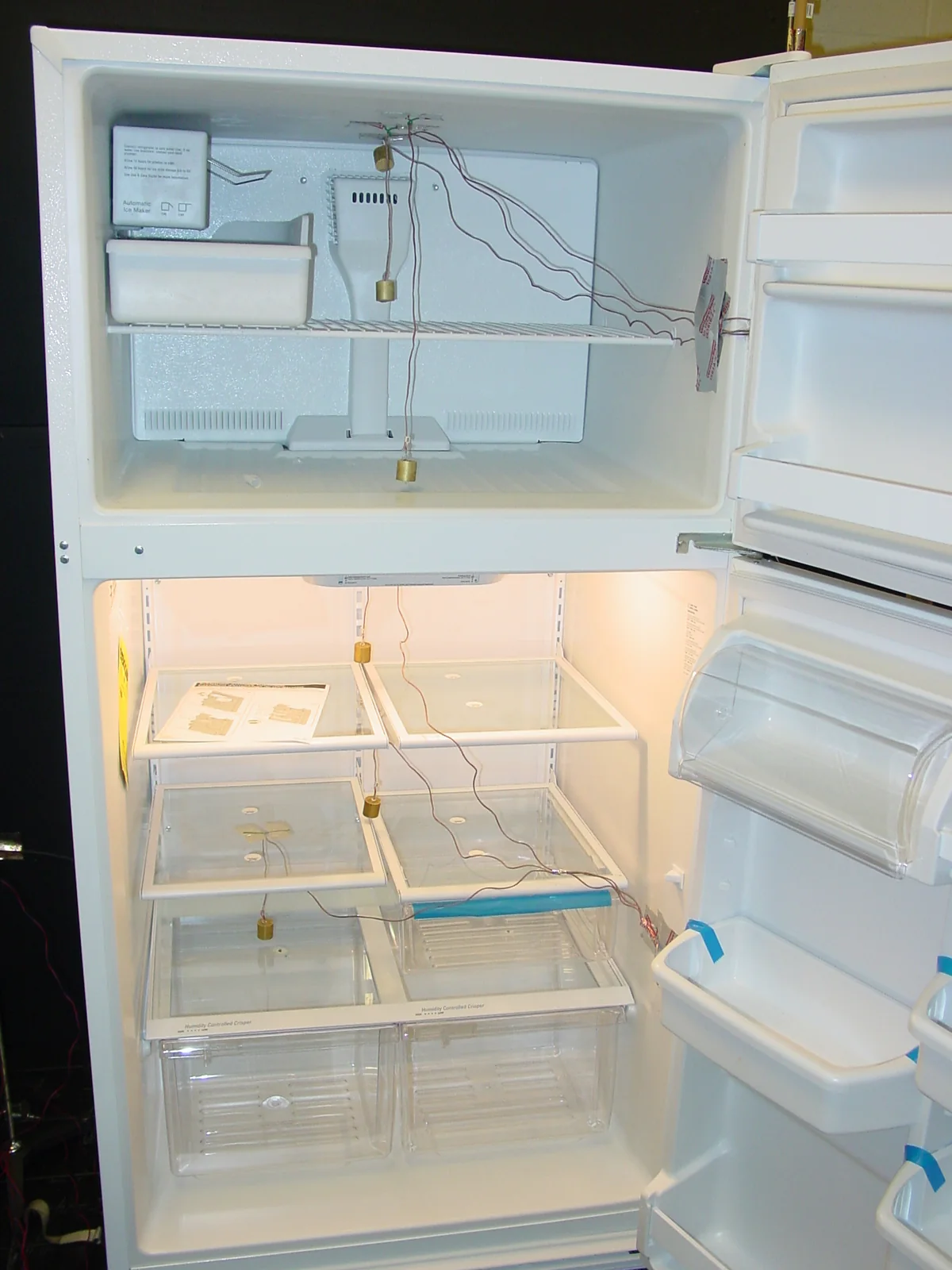 Refrigerator compartment | Republic refrigerator repair Open refrigerator and freezer with temperature-test wiring visible