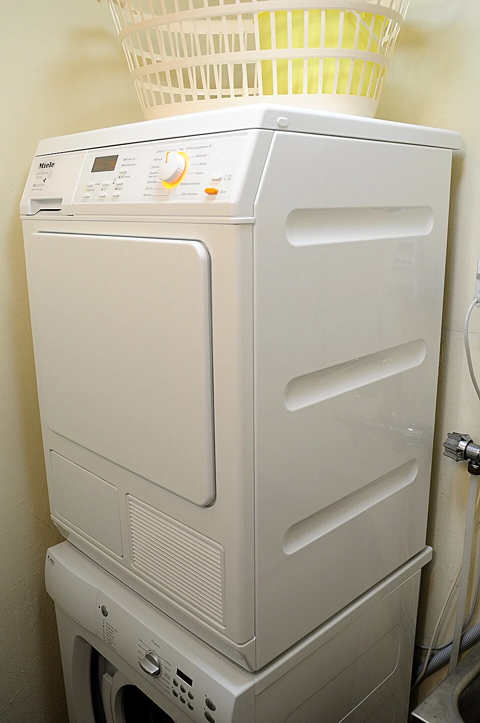 Laundry dryer | Clever dryer repair Clothes dryer installed above a washing machine