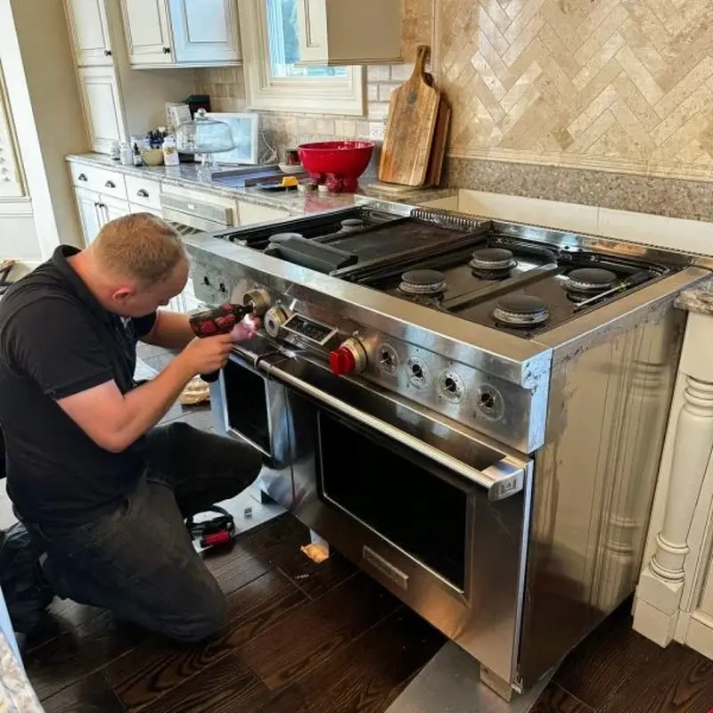 Technician accessing the front controls of a gas range